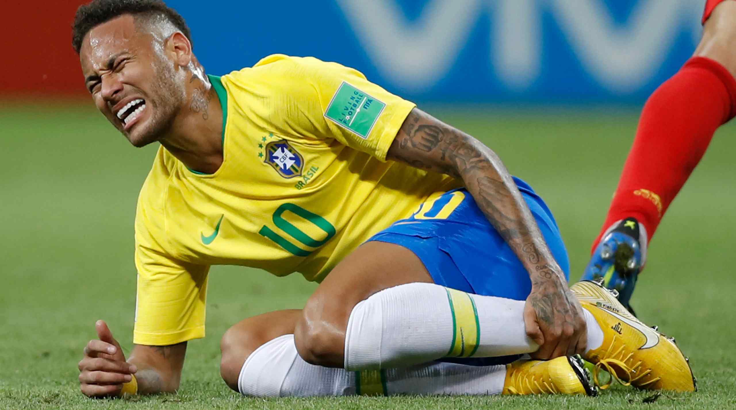 Neymar Jr. holding his leg while playing for Brazil.